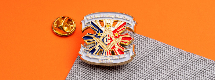 Gold square and compasses pin over red, white and blue rays with a lodge banner above and below, beside a gold clutch
