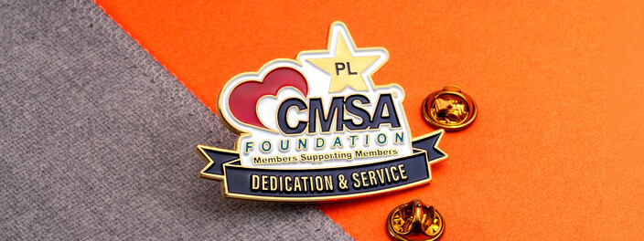 Foundation pin with a red heart, a gold star and a Dedication and Service banner, beside two gold clutches