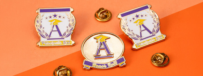 Two purple and gold Principal's List pins and a round Honor Roll pin, each with a letter A and a graduation cap