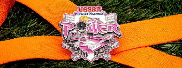 Pink USSSA Midwest Nationals 2025 Power softball pin with a skull and a player swinging a bat, on an orange ribbon over turf