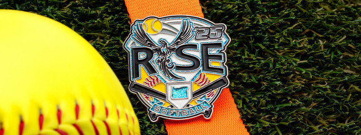 Rise 25 softball trading pin with a bird rising over home plate and glitter accents, on a softball and an orange ribbon