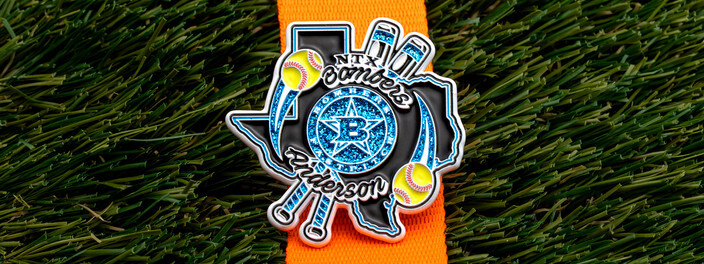 NTX Bombers softball pin shaped like Texas with softballs and a blue star, on an orange ribbon over turf